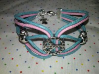 Pulsera rosa y verde agua con angelito y piezas en color plata.