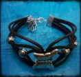 Pulsera marrón cuero con detalle de manita, mariposa y perlas plateadas